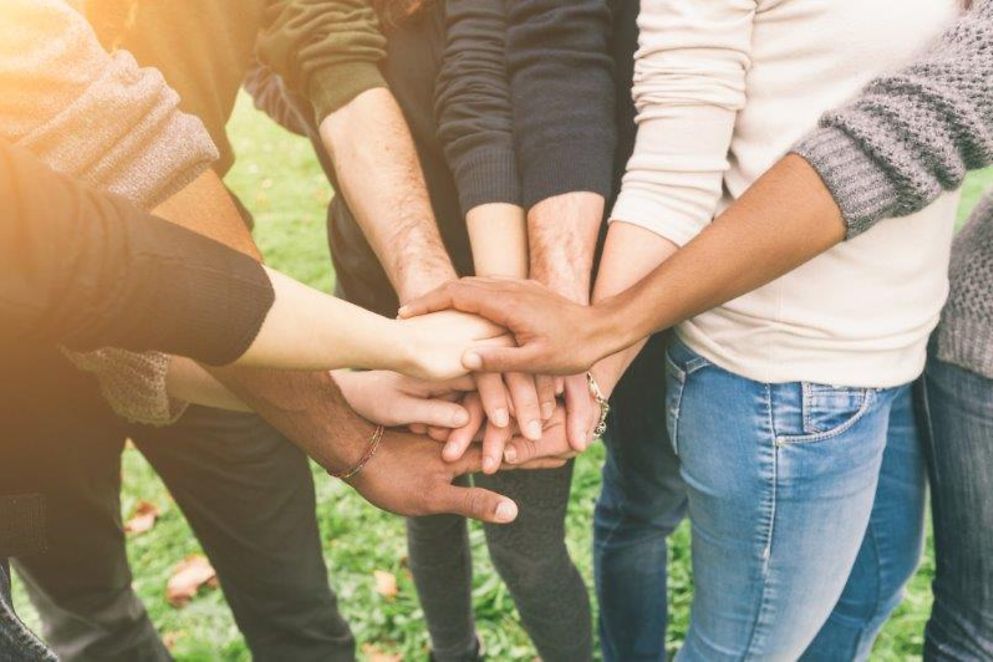 A group of people hold each other's hands