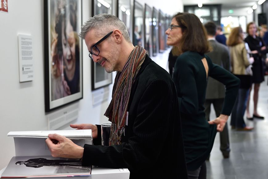 Ausstellungsgast blättert im Buch "All the people"