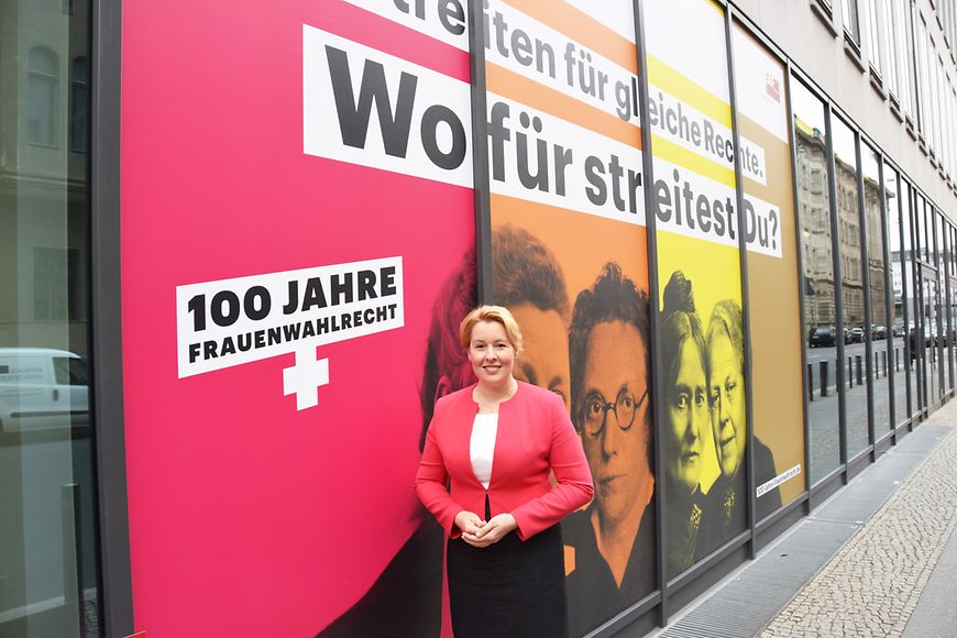 Das Bild zeigt Dr. Franziska Giffey vor der beklebten Außenfassade des Minsteriums