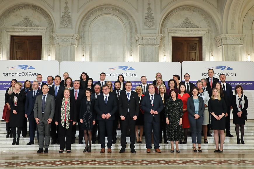 Das Bild zeigt eine Gruppe von Menschen in einem großen Saal vor Aufstellern