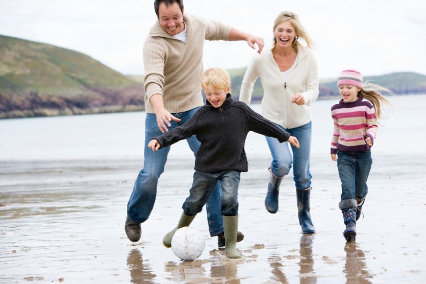 Porträt einer spielenden Familie am Strand