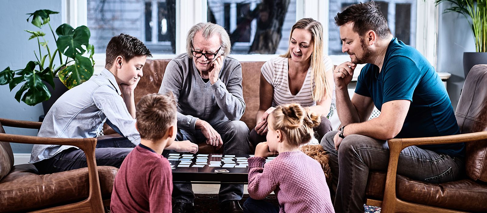 Eine Familie sitzt am Tisch und spielt 