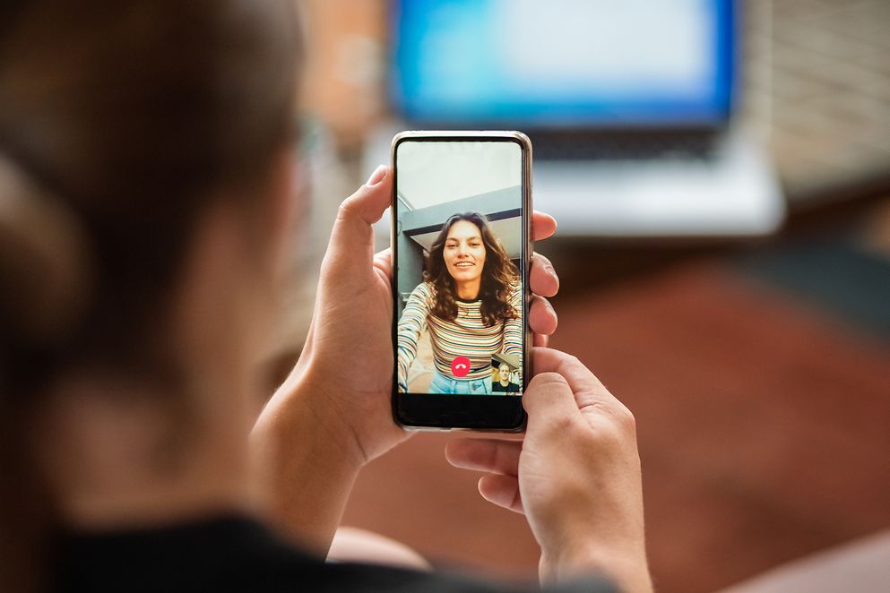 Eine junge Frau bei einem Videotelefonat mit einer anderen Frau