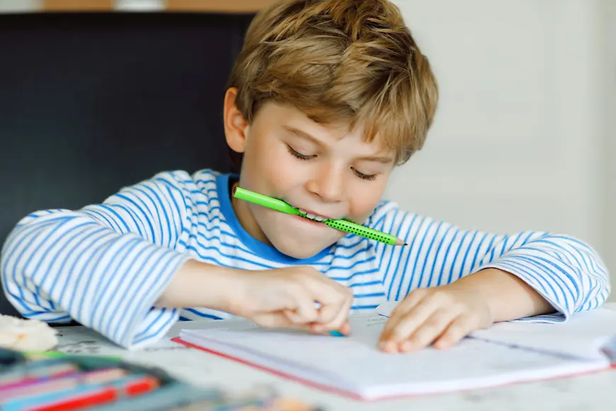 Schulkind am Tisch macht Haushaufgaben