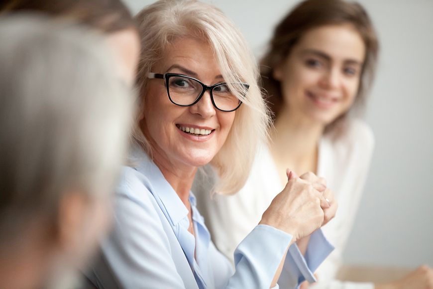 Eine Frau im Gespräch mit Kolleginnen und Kollegen