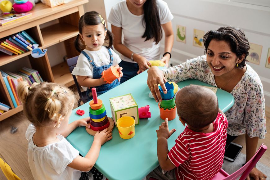 Kinder spielen mit einer Fachkraft