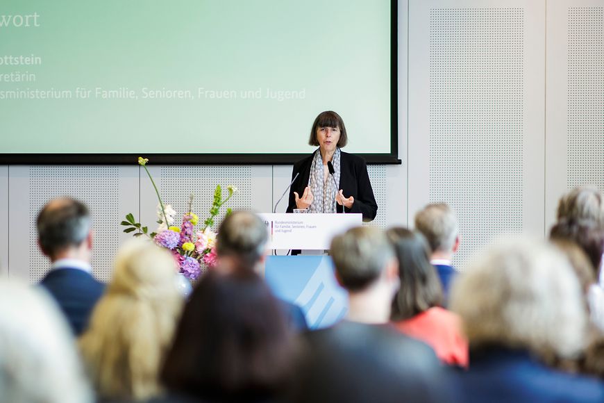 Margit Gottstein steht vor Publikum an einem Rednerpult.