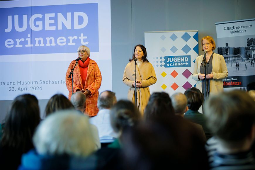 Claudia Roth, Annalena Baerbock und Lisa Paus stehen auf einer Bühne