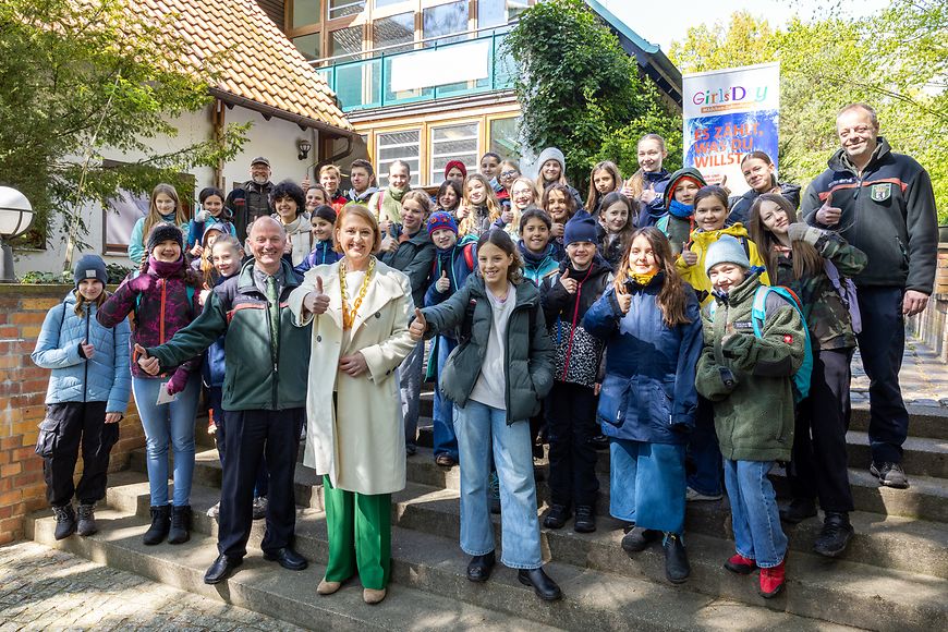 Lisa Paus und eine Gruppe Jugendlicher stehen auf einer Treppe und zeigen den Daumen nach oben