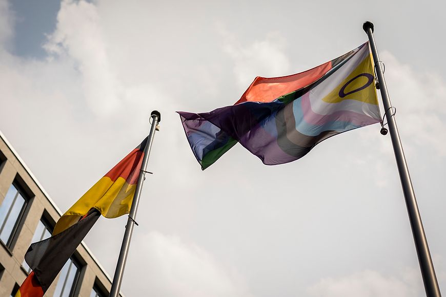 Bild der Deutschland- und Regenbogenflagge vor dem Bundesfamilienministerium 