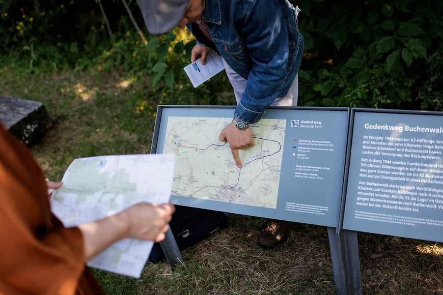 Lisa Paus beim Spaziergang mit anderen Personen auf einem Weg im Wald