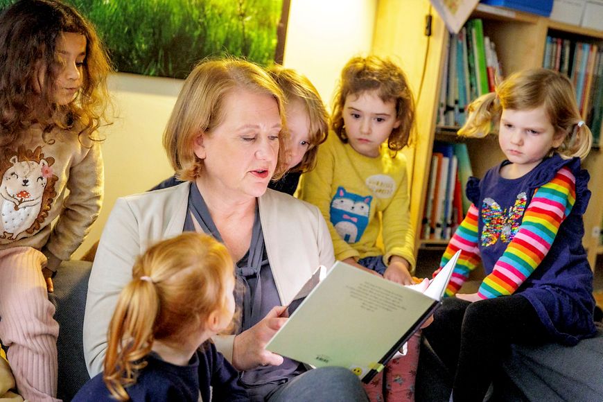 Bundesjugendministerin Lisa Paus liest zusammen mit Kindern ein Buch. 