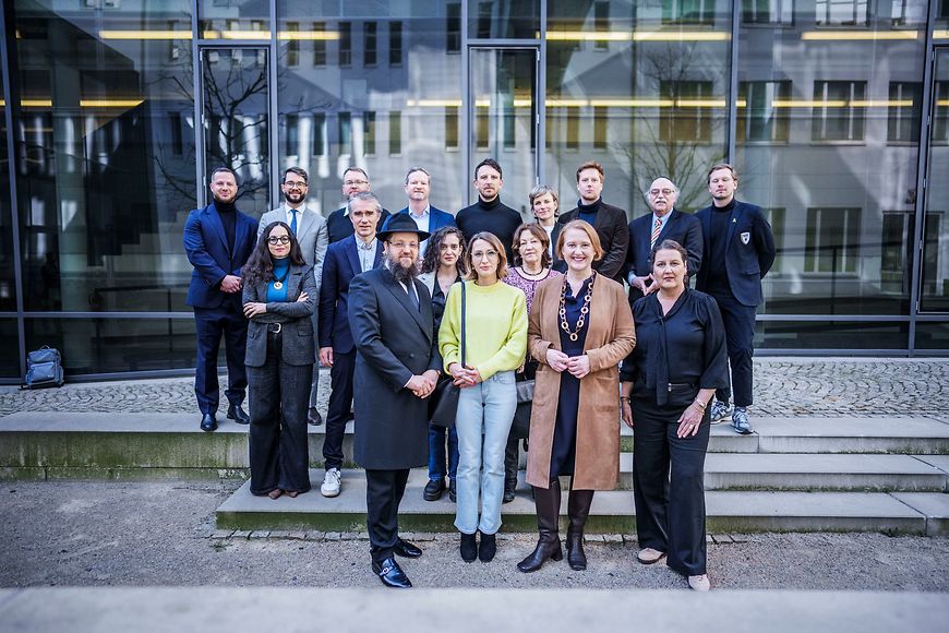 Lisa Paus mit einer Gruppe von Leuten vor einer Fensterfront