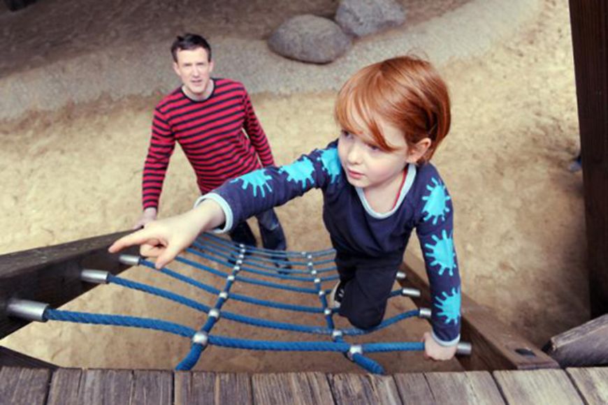 Ein Vater mit seinem Kind auf dem Spielplatz